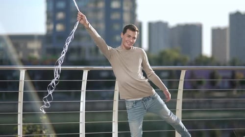 Happy Man Dancing with Balloons in City