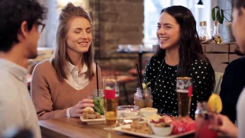 Friends Together at Restaurant Toasting Drinks at Table