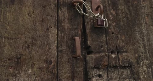 Zoom in on an old rusty metal handle on an old oak gate