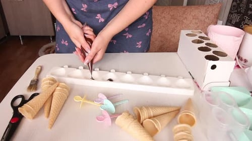 Eine Frau füllt flüssige Schokolade in eine Silikonform. Macht Zuckerguss für hausgemachtes Eis
.