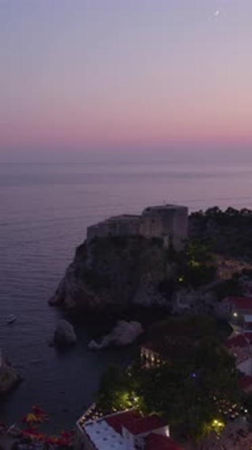 Lovrijenac Fort rising from the sea at sunset in Dubrovnik, Croatia. Aerial, Vertical Video