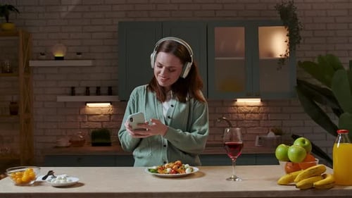 Woman with Headphones Dancing and Listening to Music