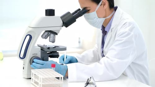 Female Scientist Working with Microscope in Laboratory