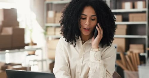 Woman Talking on Phone and Working at Laptop