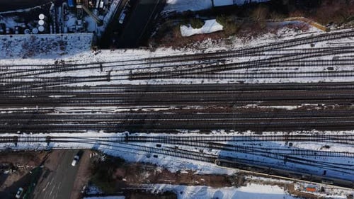Statische Luftaufnahme von oben nach unten aus einzigartiger Perspektive mehrerer verschneiter Bahngleise in Bielefeld, Deutschland
