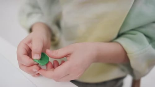 Anonymous Hands of Child Kneading Small Piece of Green Modelling Clay