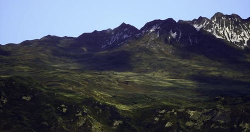 Mountain Landscape During Daylight with Snow Capped Peaks and Green Valleys