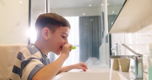 Boy Brushing Teeth in Modern Bathroom