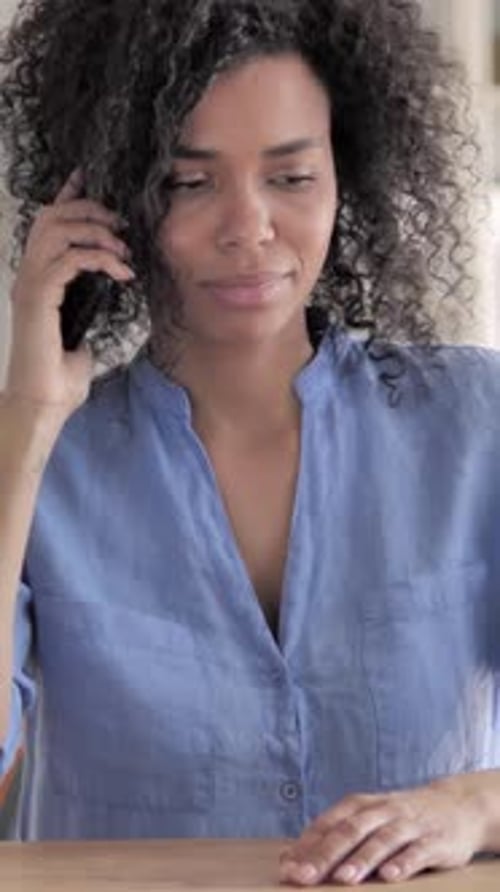 Smiling Woman Talking on Mobile Phone Indoors