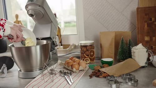 Frau, die zu Hause kocht, verwendet einen elektrischen Mixer, um Teig zuzubereiten