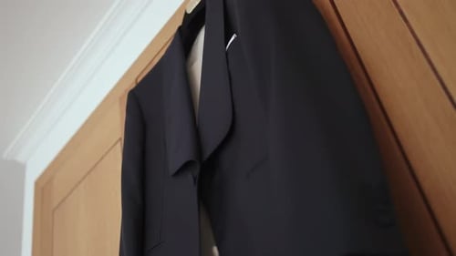 Black Suit Hanging on a Wooden Door