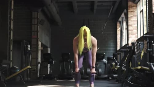 Gorgeous Female Professional Bodybuilder Doing Workout Exercises in Gym