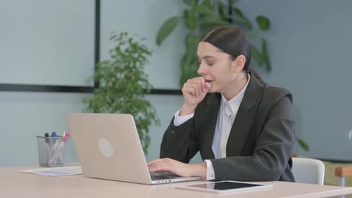 Woman Coughing While Using Laptop at Office