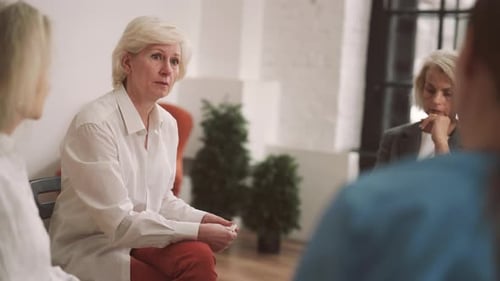 Depressed Woman Talking with Group Mates and Therapist in Psychological Center Portrait of Serious
