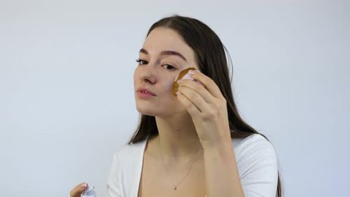 Woman Applying Foundation to Face with Beauty Blender