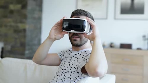 Man Wearing Virtual Reality Goggles. Studio Shot, White Couch
