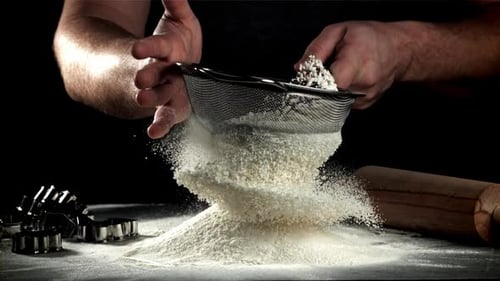 Der Koch siebt das Mehl, gefilmt mit einer Hochgeschwindigkeitskamera mit 1000 Bildern pro Sekunde