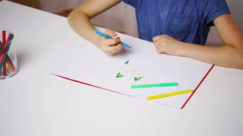 Child Drawing with Markers at Table