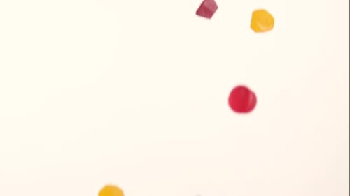 Colorful gummy candies falling on a white background