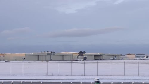 Hangares de aviones en un aeropuerto cubierto de nieve en invierno. Amplios