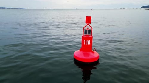 Closeup Aerial View of a Red Navigation Buoy Floating in the Calm Waters of the Sea The Buoy Ensures