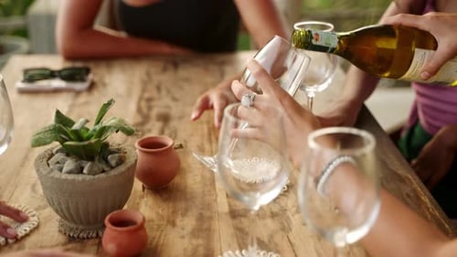 Woman Fill Glasses of Her Friends Pouring White Wine in Sea View Restaurant Female Hands Hold Bottle