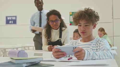 Student Using Smartphone in Bright Classroom