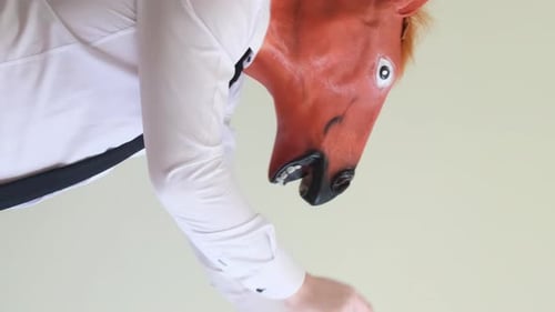 Crazy Man Dancing in Horse Mask on Background in Studio Vertical Video