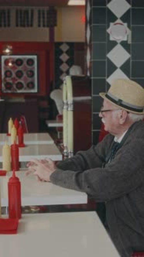 Vertical of Waitress Bringing Menu to Elderly Customer
