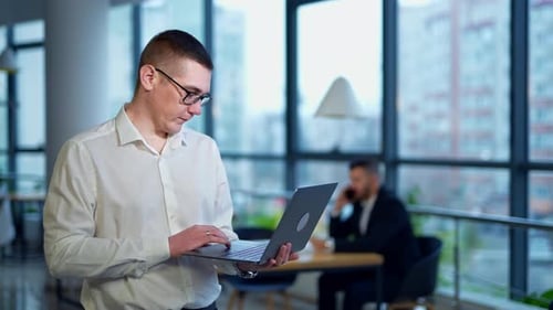 Handsome businessman working in the modern office. Young confident smart office worker.