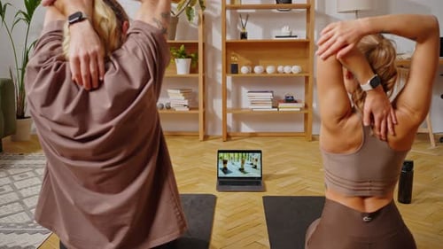Two People Exercising While Watching Online Yoga Lesson