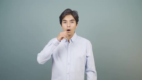 Man Coughing Into Hand Against Grey Background