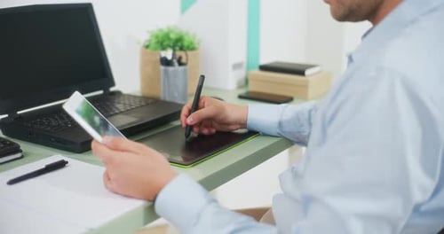 Young Adult Working with Graphic Tablet at Desk