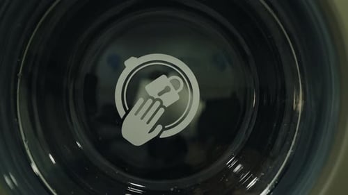 CloseUp of Washing Machine Displaying Hand Wash Symbol on Door Glass
