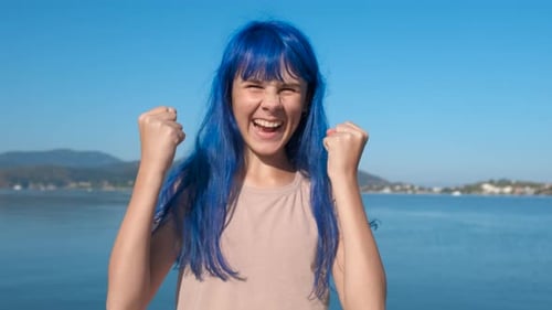 Trendy blue haired teen by sea.