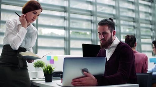 Young business professionals talking together in a modern office workplace