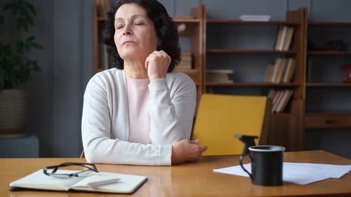 Pensive Woman Sitting at Desk in Home Office