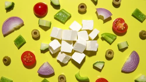 Ingrédients pour la salade grecque traditionnelle sur fond jaune, vue de dessus