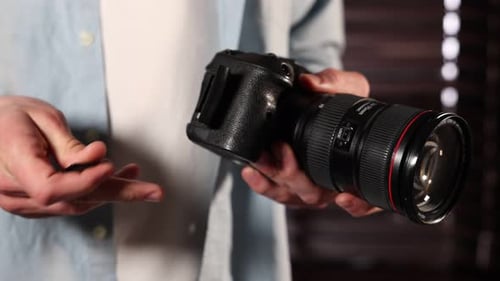 Man inserting SD memory card into photo camera indoors, closeup