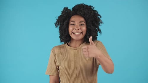 Woman Gives Two Thumbs Up on Blue Background