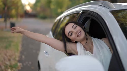 Woman Smiling with Arm Out Car Window