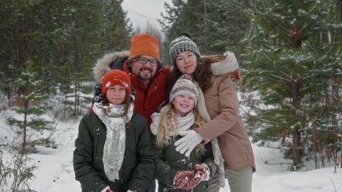 Portrait of Happy Active Family with Kids Hugging in Winter Forest