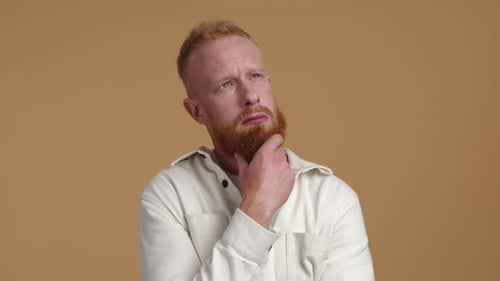 Closeup View of a Young Man in His 30s Looking Above While Overthinking