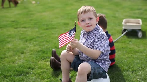 Young Boy with American Flag Sitting on Soccer Ball
