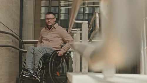 Man in Wheelchair Going Down Ramp
