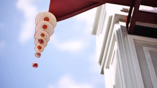 Red and White Decorative Ornaments Hanging Outside Building