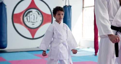 Child Practicing Karate with Instructor in Gym