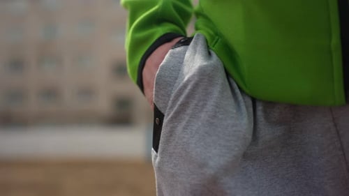 Man's Hand Puts Stuff in Jogging Pants Pocket