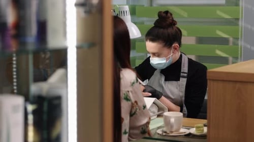 Manicurist Filing Client's Nails in a Salon