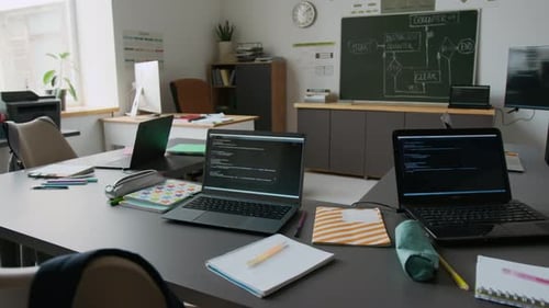 Interior of Classroom with Desks with Laptops Displaying Code